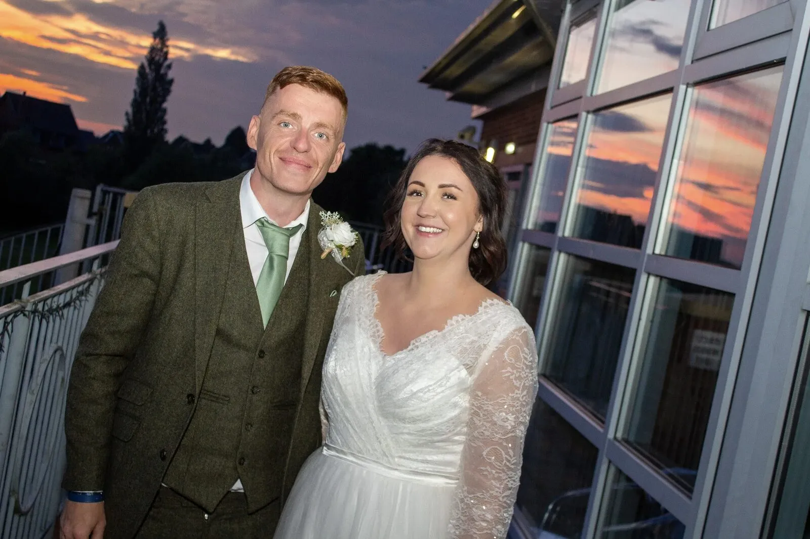 A couple on a balcony at sunset, one of our wedding photographs