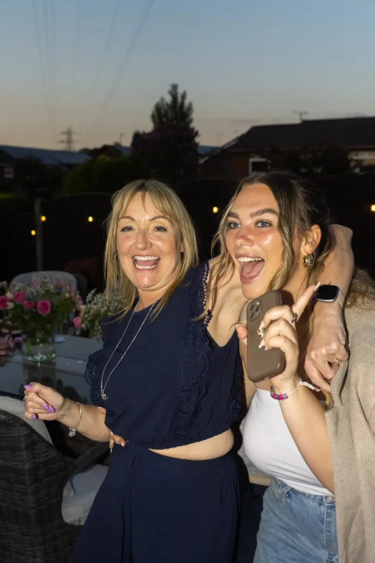 Friends laughing at a dusk garden party