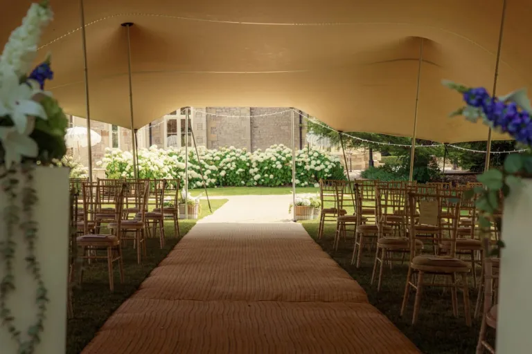 A stretch tent ceremony aisle set with chairs before guests arrive